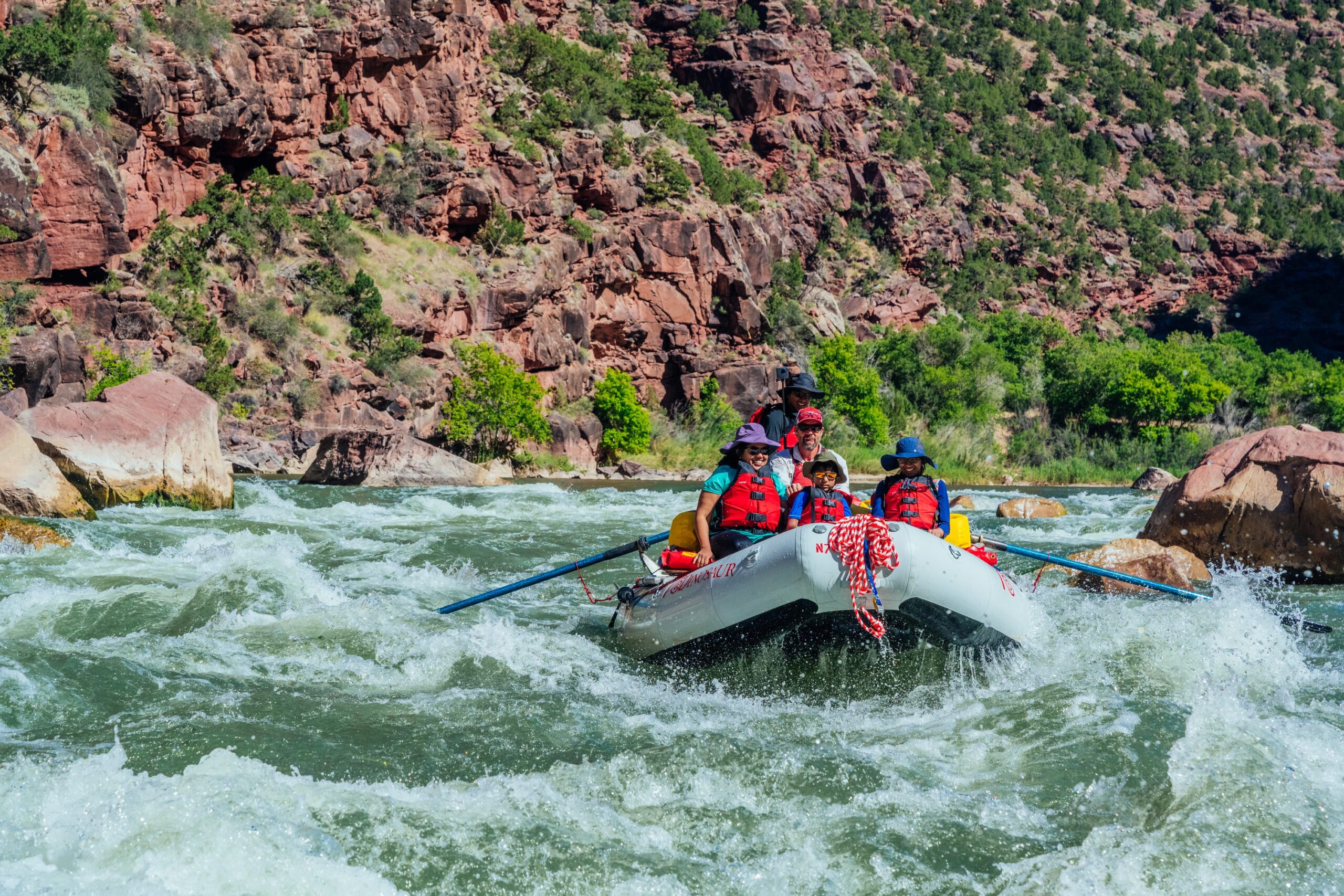 Family, Utah Outdoor Recreation river rafting in Utah wearing life jackets.