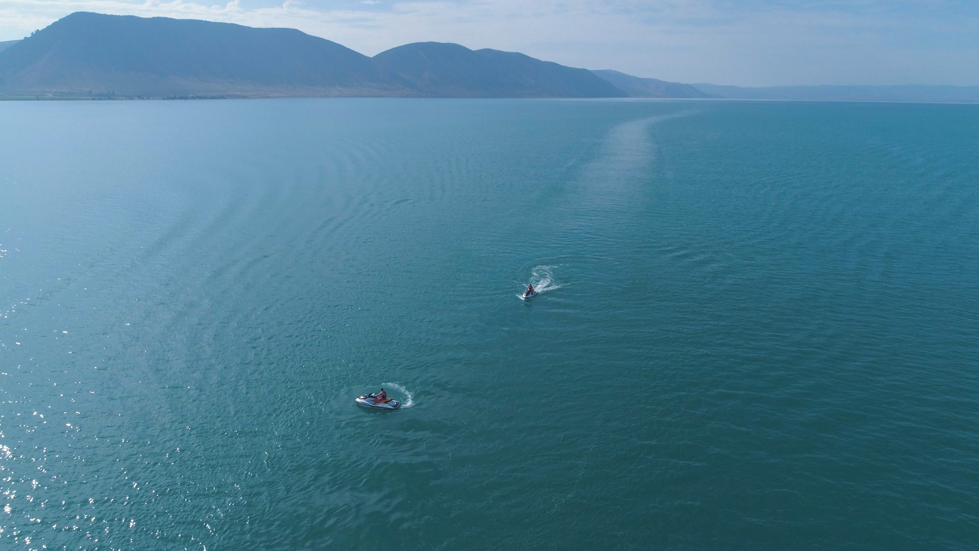 People riding personal watercraft on a lake in Utah